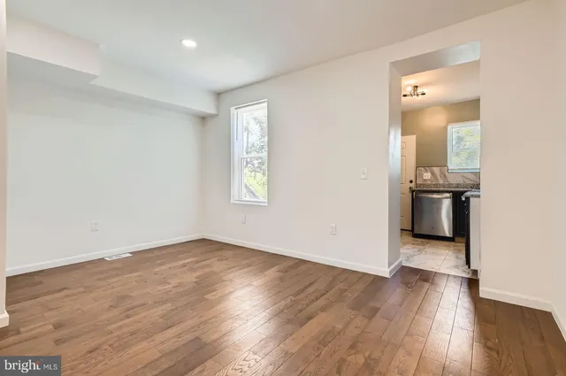 a view of an empty room with wooden floor