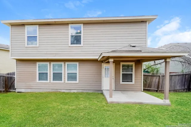 a front view of a house with a yard and fence