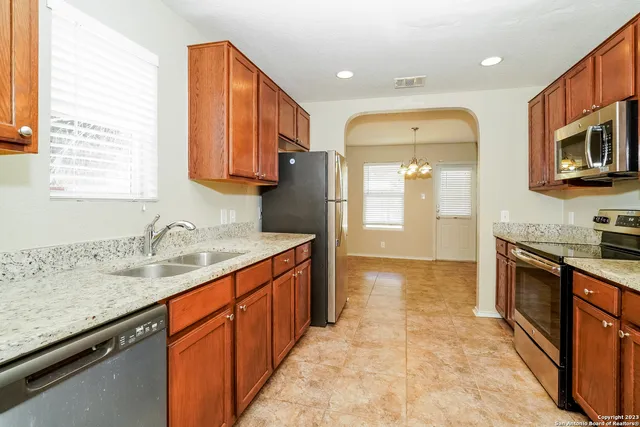 a kitchen with stainless steel appliances granite countertop a sink stove and refrigerator