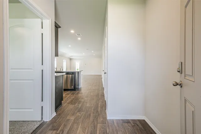 a view of a hallway with wooden floor