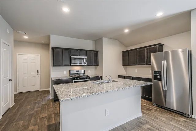 a kitchen with stainless steel appliances granite countertop a sink stove and refrigerator