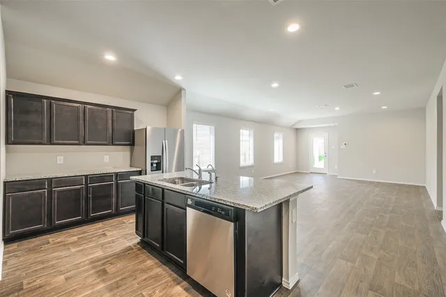 a kitchen with stainless steel appliances granite countertop a sink stove and cabinets