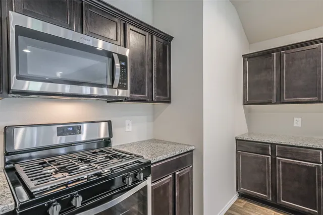 a kitchen with stainless steel appliances granite countertop a stove and a microwave