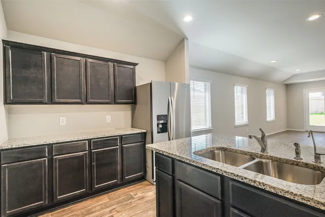 a kitchen with stainless steel appliances granite countertop a sink refrigerator and microwave