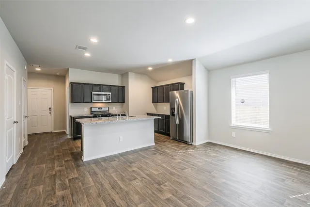 a view of kitchen with refrigerator microwave and cabinets
