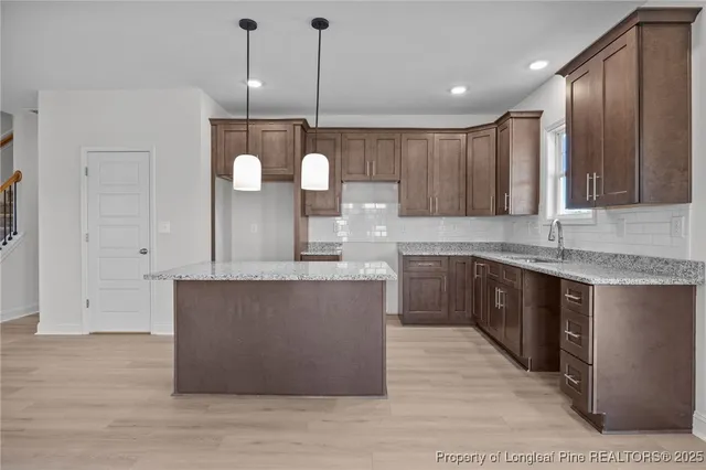 a large kitchen with kitchen island a sink stainless steel appliances and cabinets