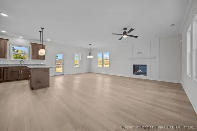 a view of an empty room with a kitchen and a fireplace