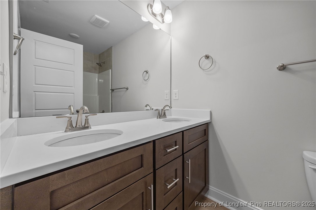 3162 Cameron Hill Road Cameron, NC 28326 - Photo 23 of 45 a bathroom with a sink a toilet and a mirror