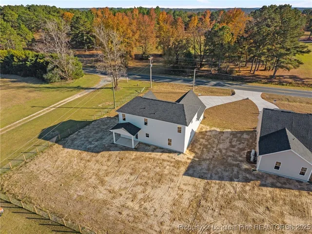 a backyard of a house with a yard and large tree
