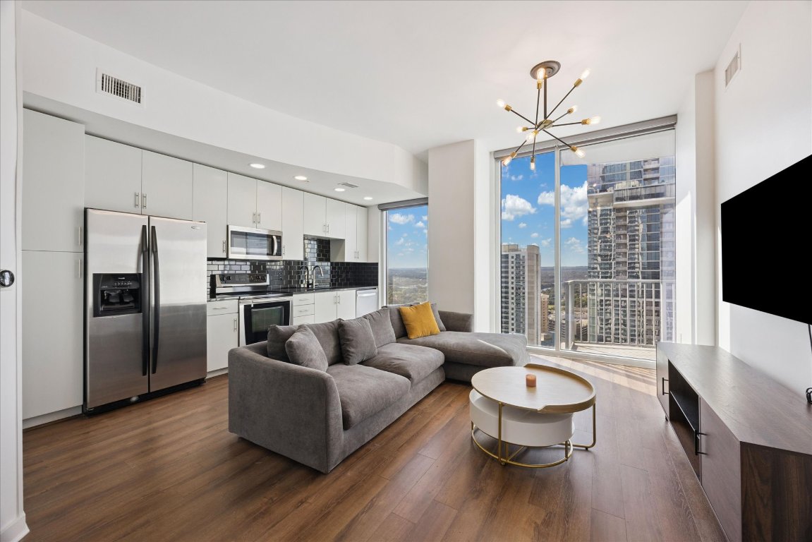 360 Nueces Street, Unit 2704 Austin, TX 78701 - Photo 1 of 40 a living room with furniture wooden floor and a flat screen tv