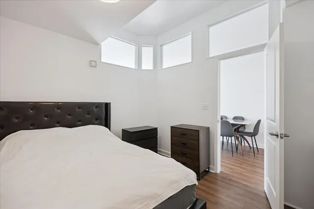 a bedroom with a bed and wooden floor