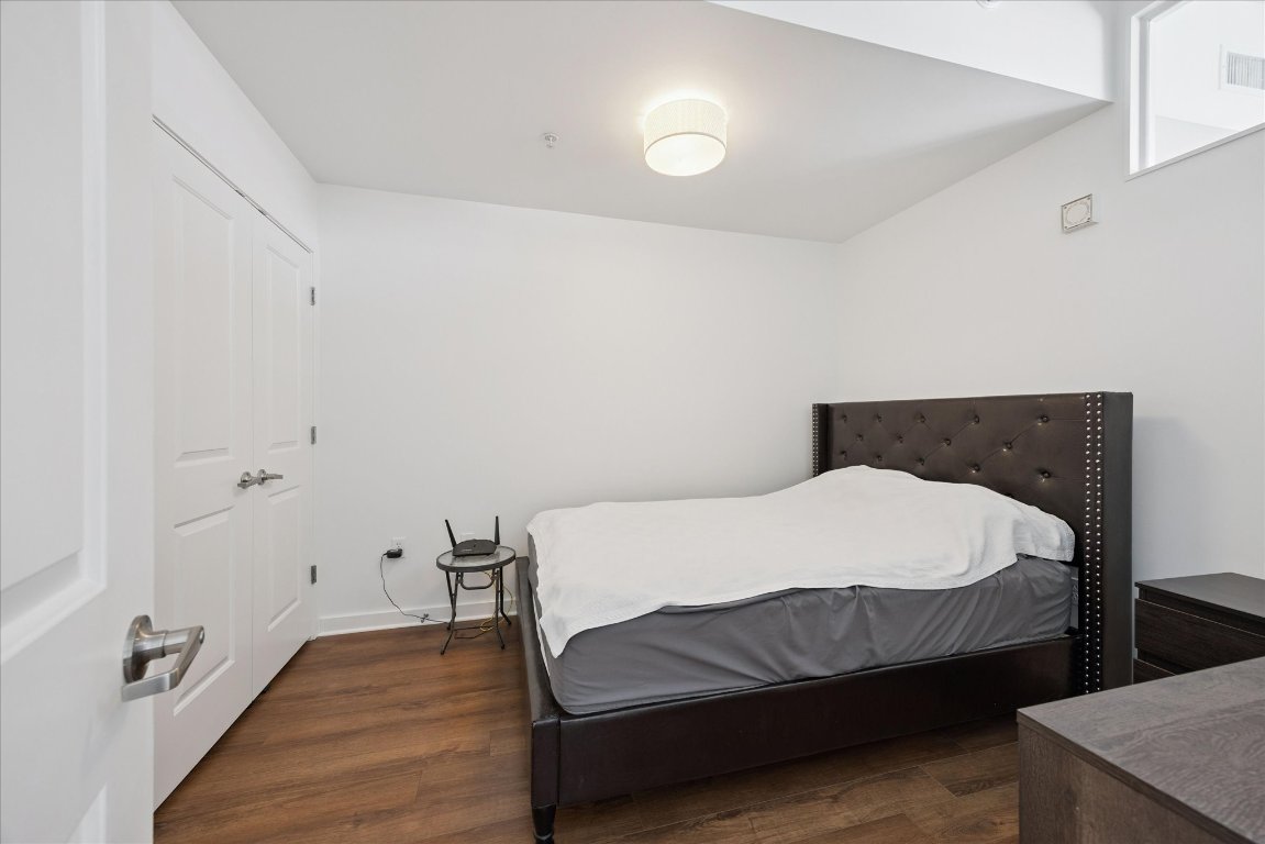 360 Nueces Street, Unit 2704 Austin, TX 78701 - Photo 25 of 40 a bedroom with a bed and wooden floor