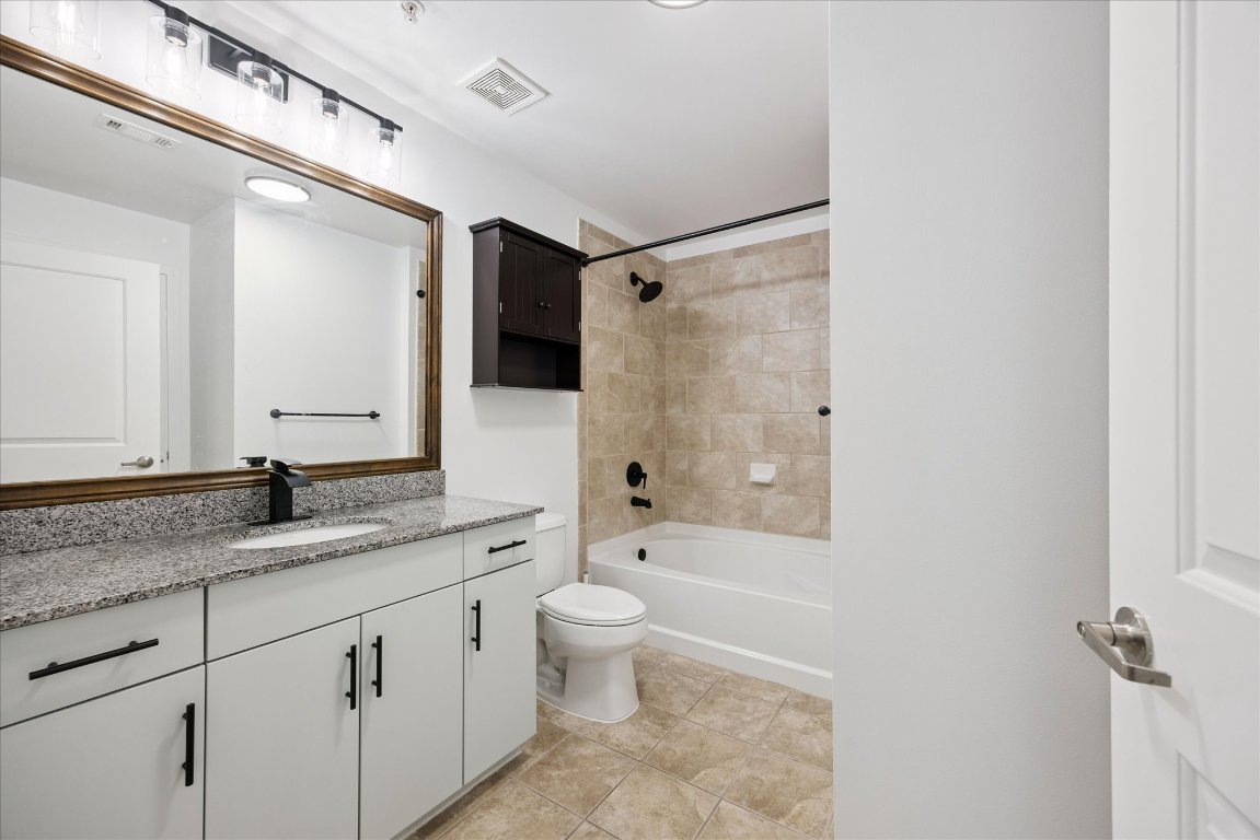 360 Nueces Street, Unit 2704 Austin, TX 78701 - Photo 27 of 40 a spacious bathroom with a granite countertop sink toilet mirror and shower