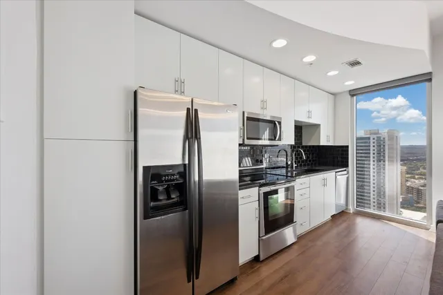 a kitchen with stainless steel appliances a refrigerator sink and microwave