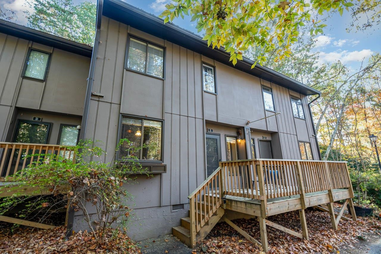a view of a house with a wooden deck and furniture
