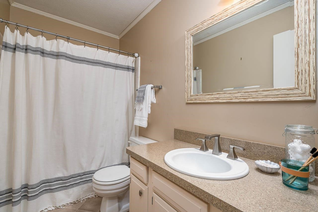 3080 Colony Road, Unit 3080E Durham, NC 27705 - Photo 26 of 31 a bathroom with a granite countertop sink toilet and a mirror