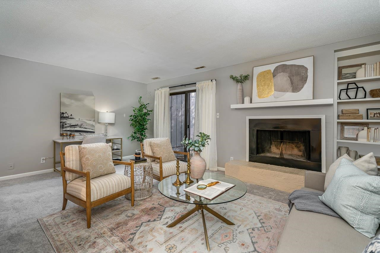 3080 Colony Road, Unit 3080E Durham, NC 27705 - Photo 4 of 31 a living room with furniture a rug a fireplace and a window
