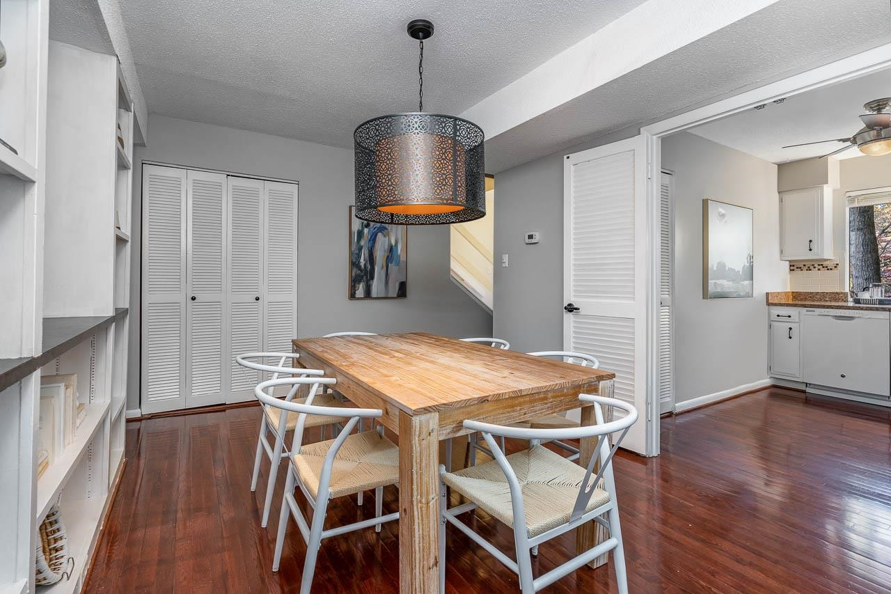3080 Colony Road, Unit 3080E Durham, NC 27705 - Photo 10 of 31 a dining room with wooden floor a chandelier a wooden table and chairs