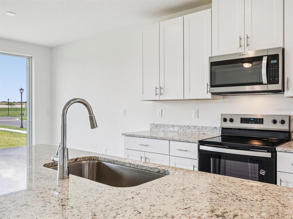 1646 Bark Rdg Drive Auburndale, FL 33823 - Photo 12 of 34 a kitchen with stainless steel appliances granite countertop a sink and a stove top oven