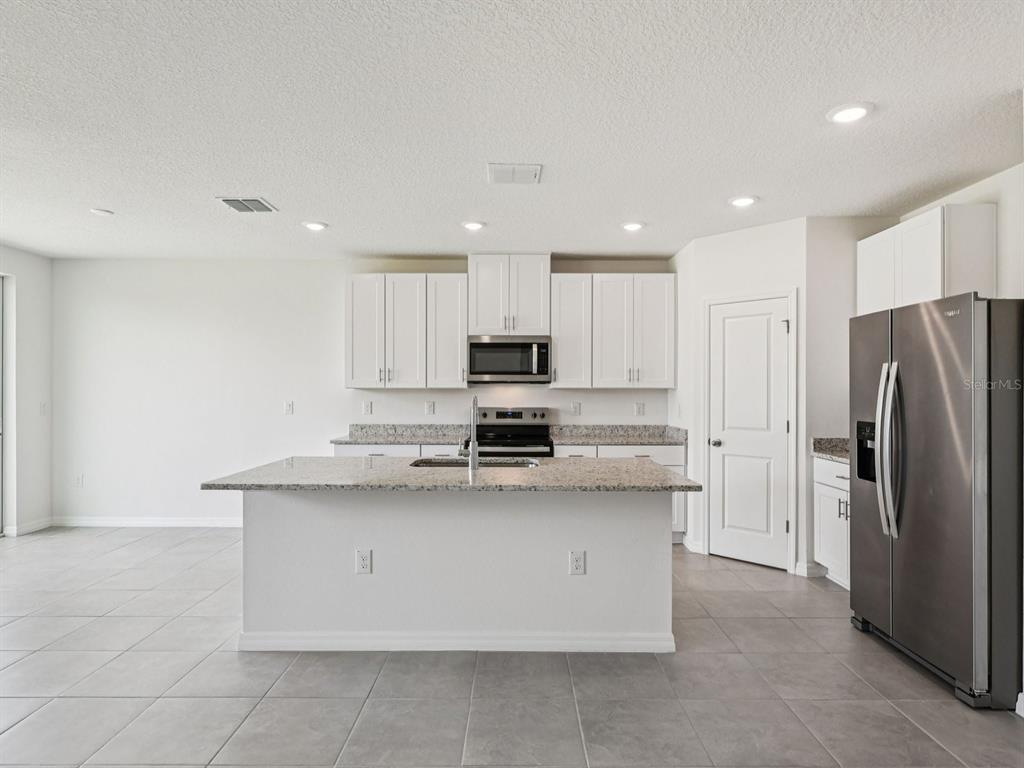 1646 Bark Rdg Drive Auburndale, FL 33823 - Photo 13 of 34 a large kitchen with stainless steel appliances granite countertop a stove a refrigerator a sink and dishwasher