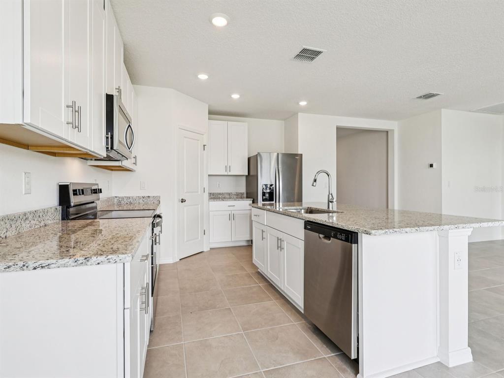 1646 Bark Rdg Drive Auburndale, FL 33823 - Photo 15 of 34 a kitchen with stainless steel appliances granite countertop a sink and a stove