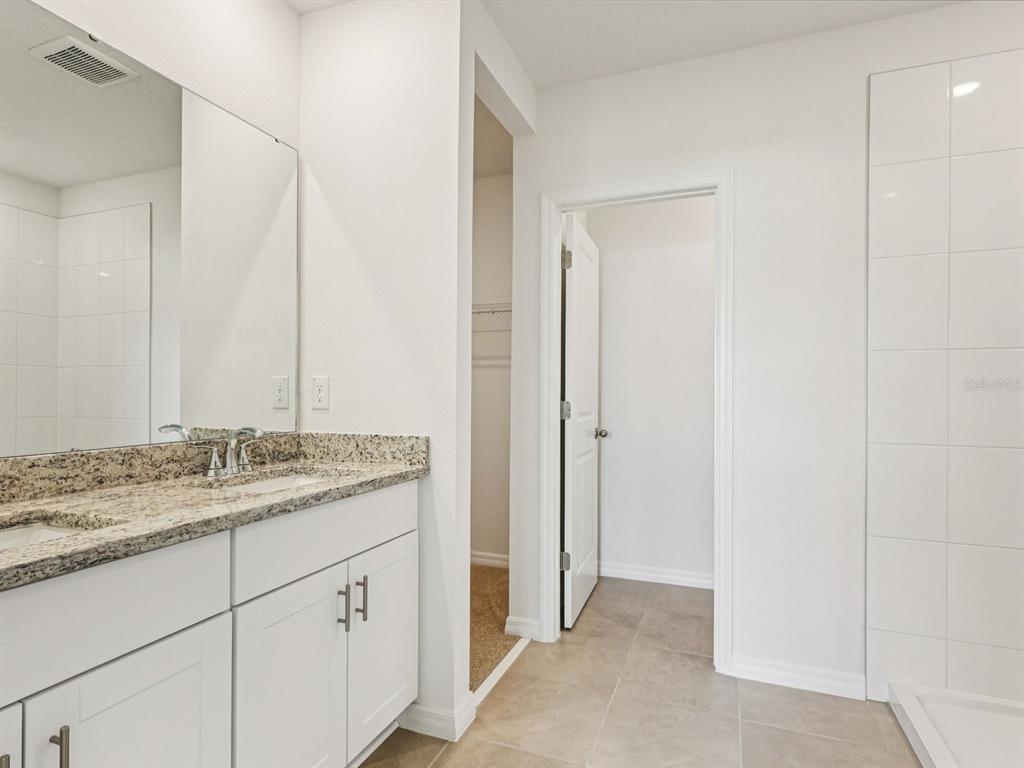 1646 Bark Rdg Drive Auburndale, FL 33823 - Photo 26 of 34 a bathroom with a granite countertop sink and a mirror