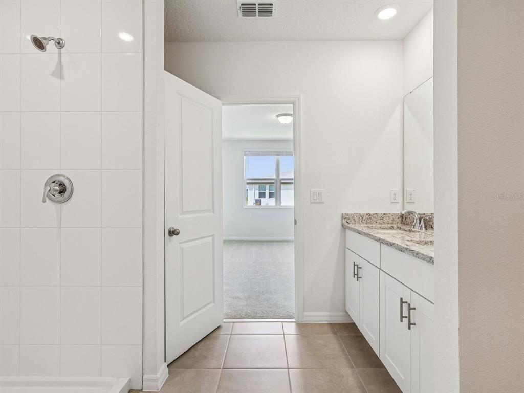 1646 Bark Rdg Drive Auburndale, FL 33823 - Photo 27 of 34 a bathroom with a granite countertop sink a mirror and a shower