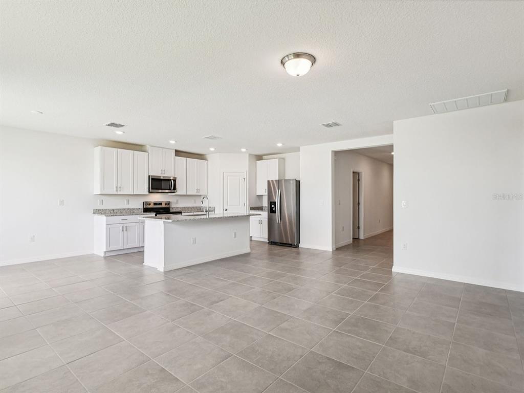 1646 Bark Rdg Drive Auburndale, FL 33823 - Photo 9 of 34 a view of kitchen with kitchen island stainless steel appliances refrigerator stove and sink