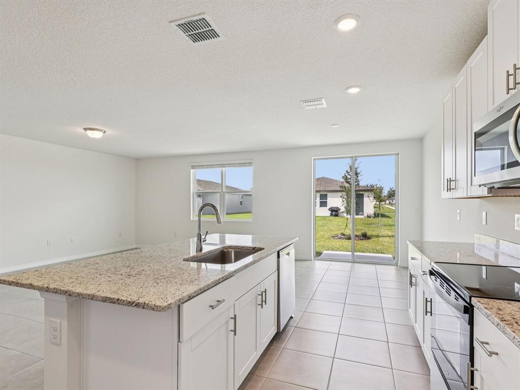 1646 Bark Rdg Drive Auburndale, FL 33823 - Photo 10 of 34 a large kitchen with a sink and cabinets