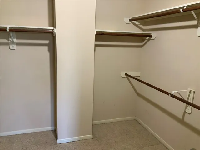 an empty room with a window and a ceiling fan