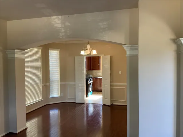 a view of a hallway with wooden floor and windows