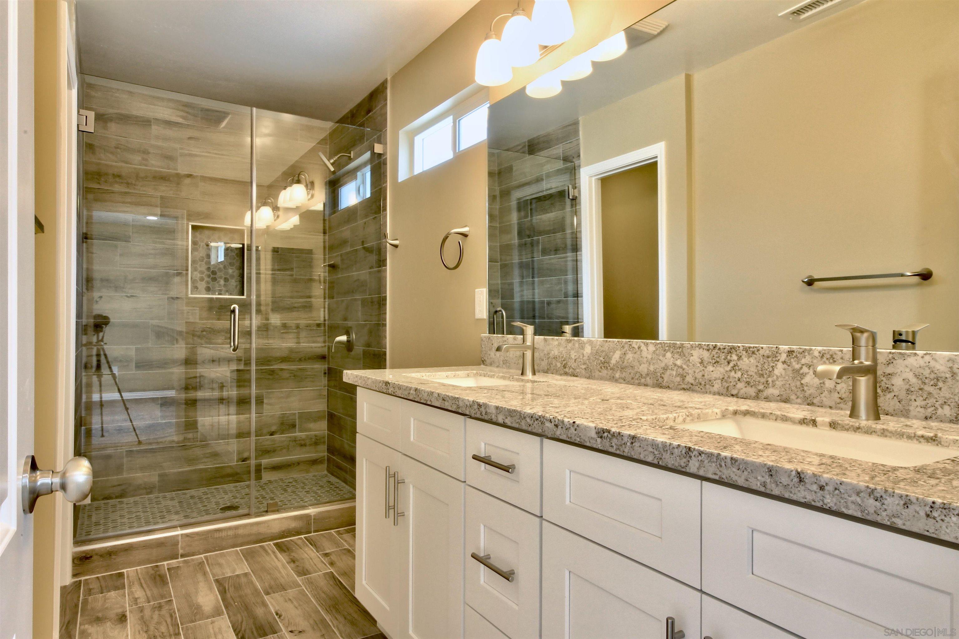 903 Concepcion Avenue Spring Valley, CA 91977 - Photo 13 of 41 a bathroom with a granite countertop sink mirror and shower