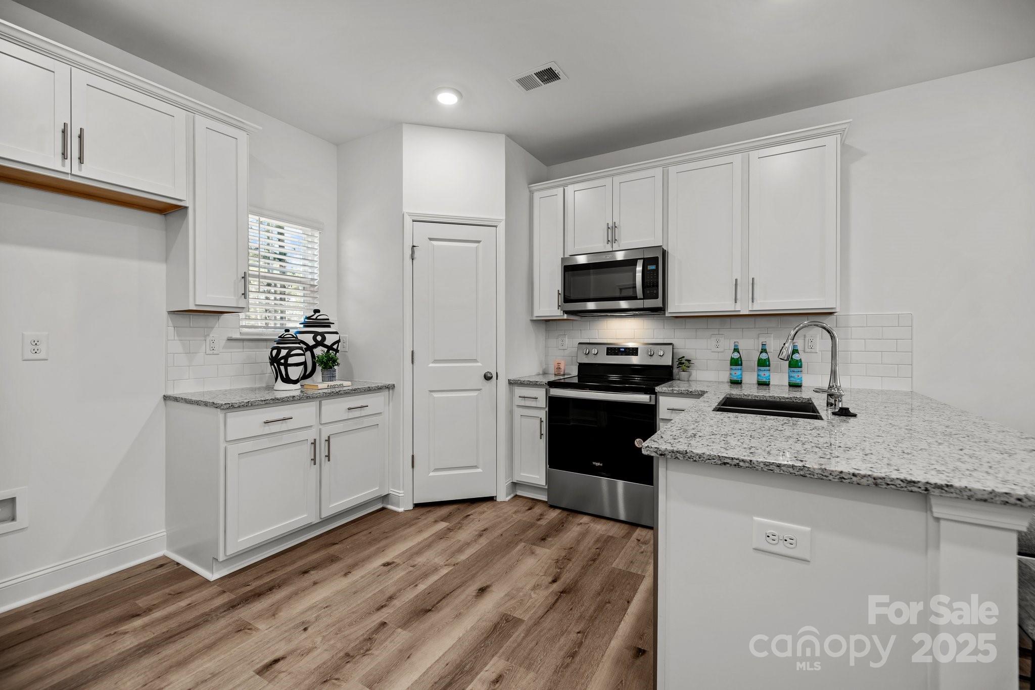 3128 Butler Hl Drive Matthews, NC 28105 - Photo 3 of 24 a kitchen with granite countertop white cabinets and stainless steel appliances