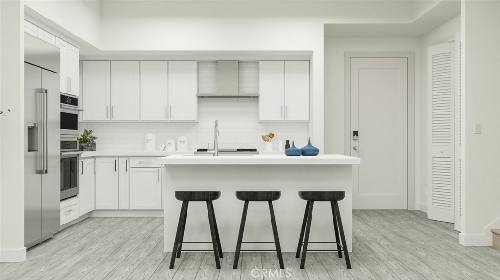 3409 Rivington Irvine, CA 92612 - Photo 1 of 1 a kitchen with stainless steel appliances kitchen island a table chairs in it and white cabinets