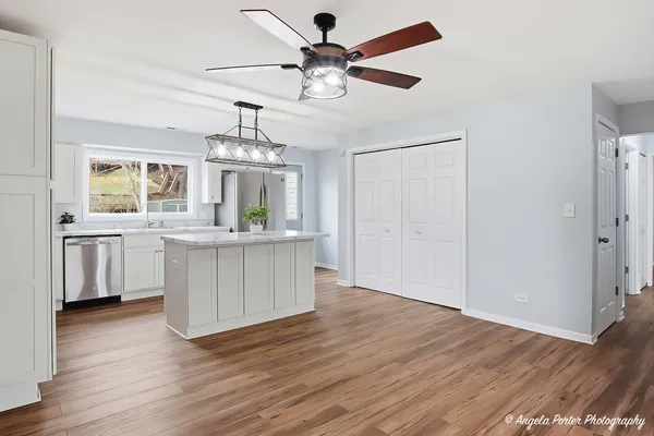 a view of a kitchen with a sink dishwasher a refrigerator and wooden floor