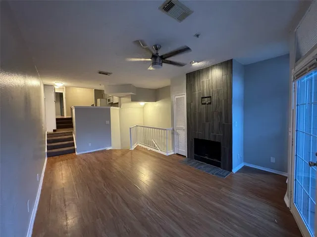 a view of a livingroom with a kitchen wooden floor and a ceiling fan