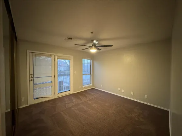 a view of an empty room with a ceiling fan
