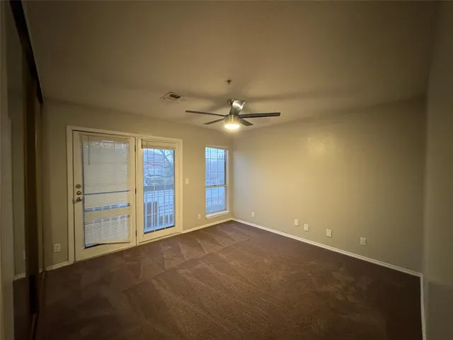 a view of an empty room with a ceiling fan