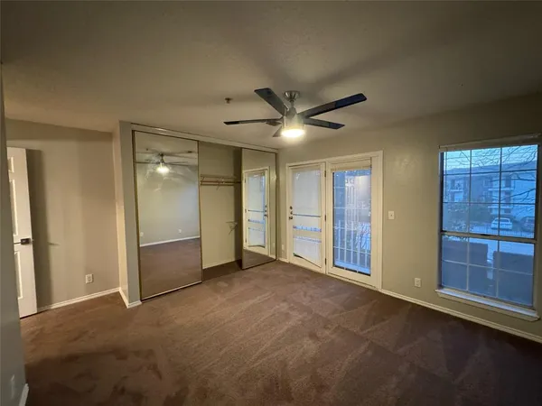 an empty room with closet and windows