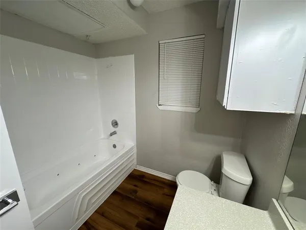 a bathroom with a toilet tub and sink