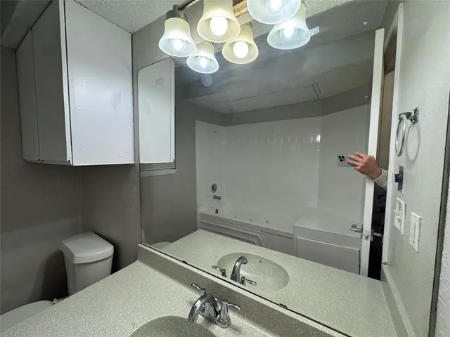 a bathroom with a sink mirror vanity and toilet