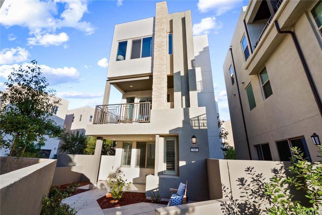 a front view of a building with a garden and plants