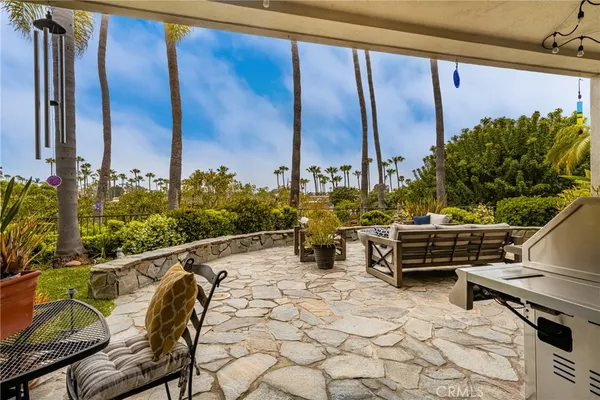 a view of a patio with table and chairs potted plants and palm trees