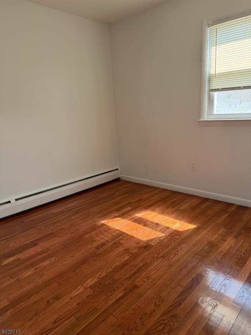 2538 Spruce Street, Unit 2 Union, NJ 07083 - Photo 13 of 29 an empty room with wooden floor and windows