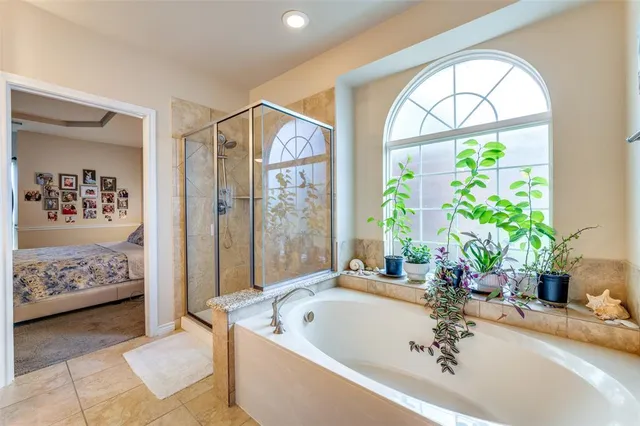 a spacious bathroom with a tub and a large window