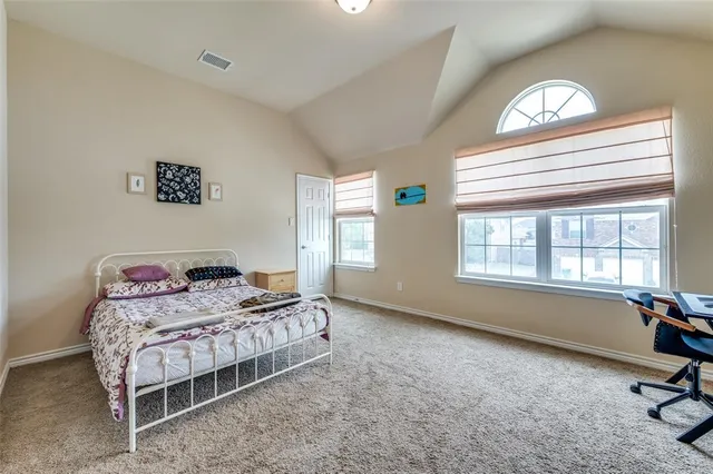 a bedroom with a bed window and a table chair