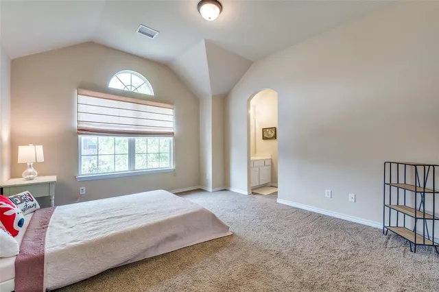 a spacious bedroom with a bed and a chandelier