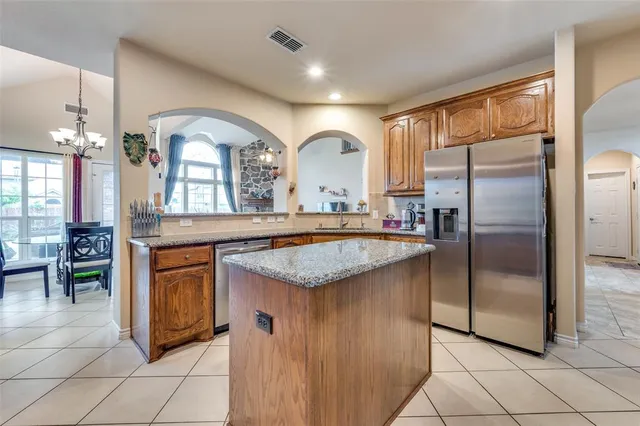 a kitchen with stainless steel appliances granite countertop a sink and a refrigerator