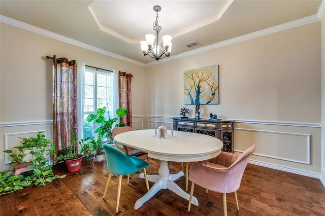 a view of a dining room with furniture and a chandelier
