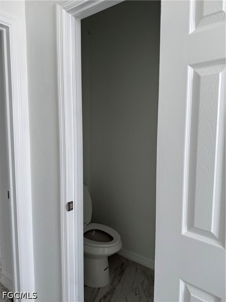 10658 Rainsville Street Port Charlotte, FL 33981 - Photo 8 of 21 a white toilet sitting next to a shower curtain
